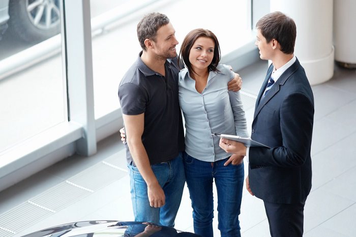 car dealer meeting with a couple