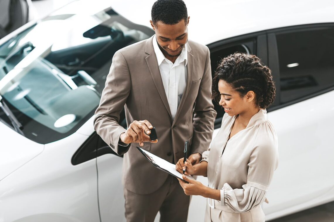 Dealer and customer reviewing paperwork