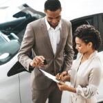Dealer and customer reviewing paperwork