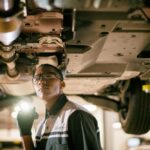 Lexus technician inspecting a hybrid battery under the vehicle